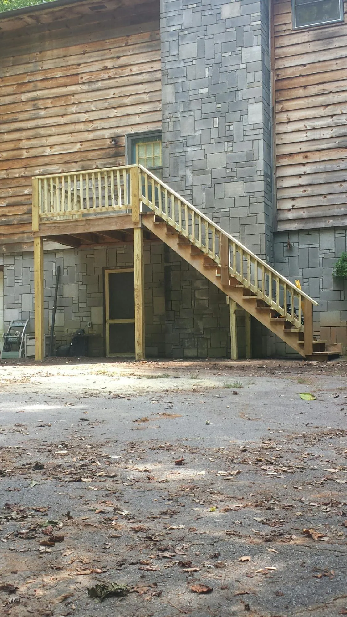 New pressure treated deck and stair landing on a log home in Camden